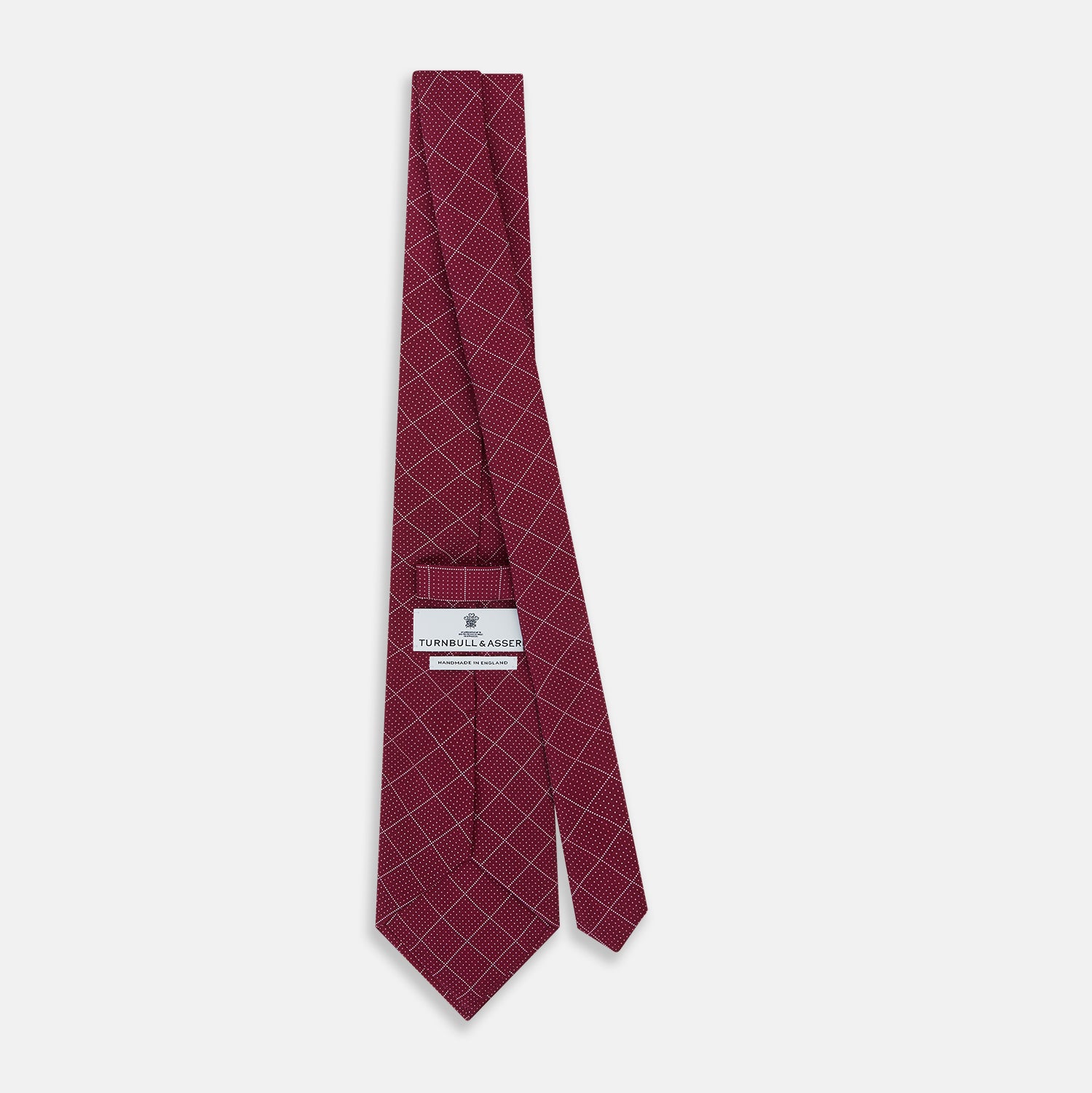 View 4 of product The Turnbull & Asser Burgundy Dotted Check Pattern Printed Silk Tie is shown rolled up on a plain white background.