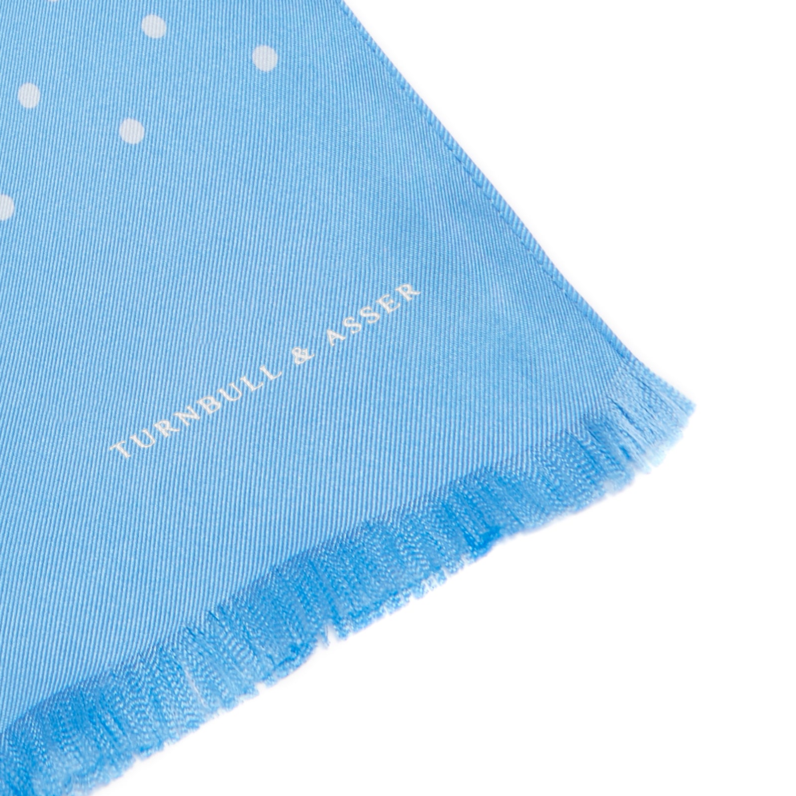 View 2 of product The Turnbull & Asser Azure and White Spotted Silk Scarf features small white polka dots, subtle fringe at the ends, and a delicate hand-printed design, displayed on a plain white background.