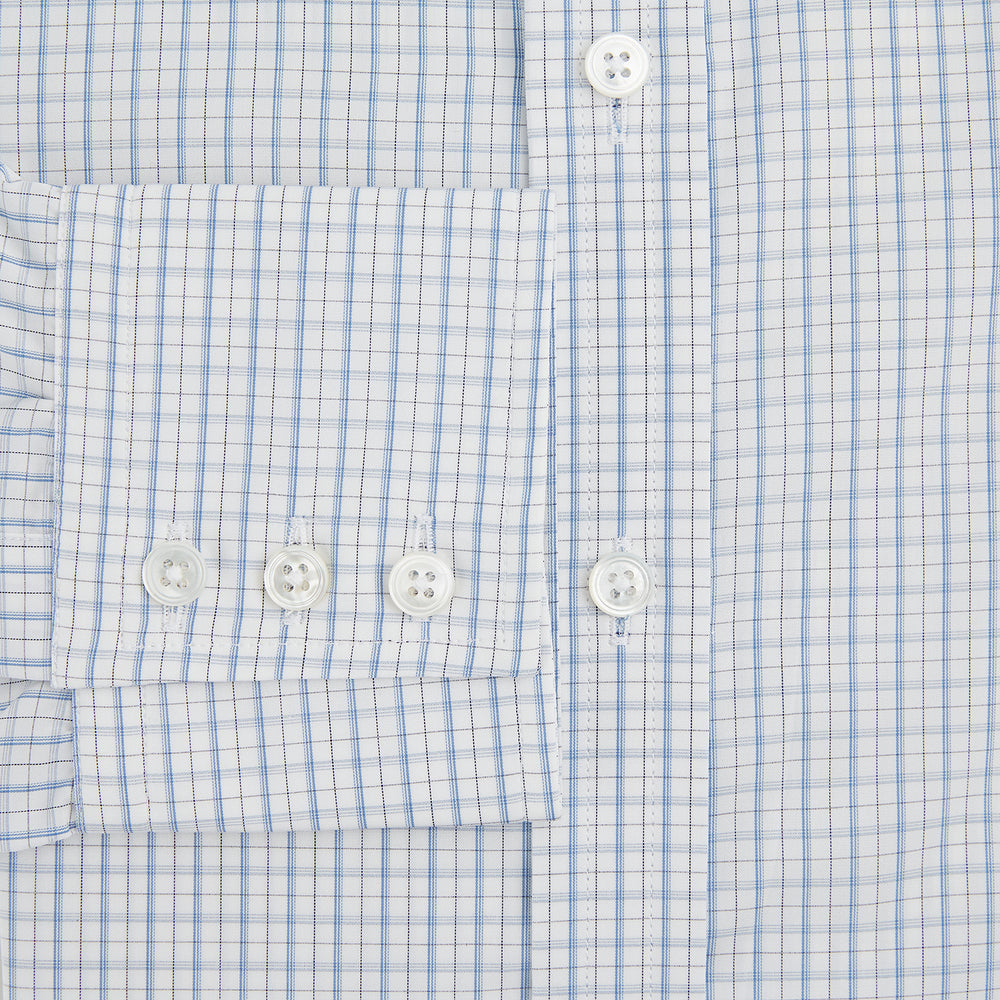 The Turnbull & Asser Sky Blue Combination Graph Check Mayfair Shirt features long sleeves, a pointed collar, buttoned cuffs, and a blue and white check pattern that showcases British craftsmanship. Displayed on a white background.