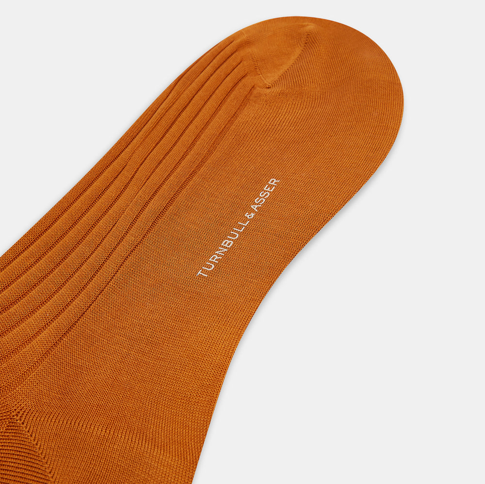 Turnbull & Asser Pumpkin Long Socks shown on a foot; bright orange and over the calf in length.