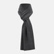 The Turnbull & Asser Plain Graphite Cashmere Knitted Scarf, draped and loosely knotted on a white background, showcases the refined elegance and timeless style of a luxury accessory.