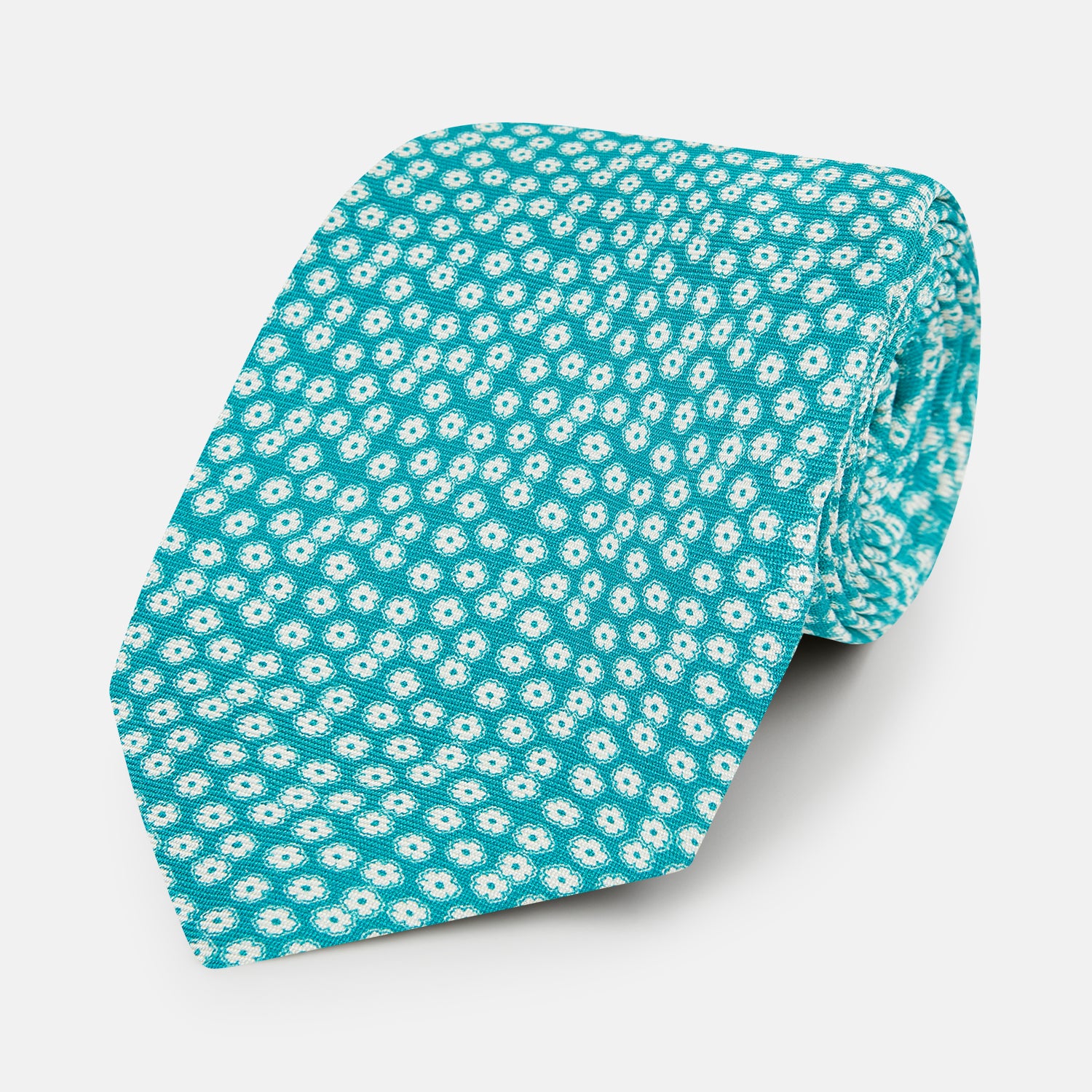 View 1 of product The Turnbull & Asser Turquoise Flower Patterned Printed Silk Tie, crafted from fine English silk, is neatly rolled on a white background.