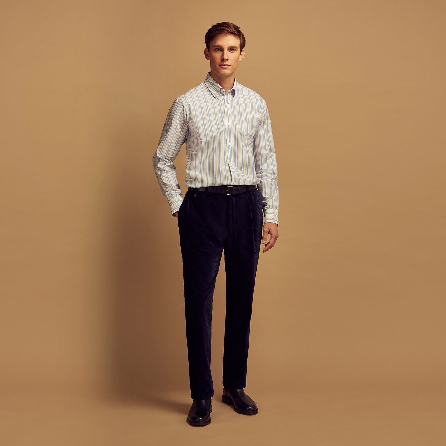 View 2 of product The Turnbull & Asser Blue Multi Stripe Wool Blend Weekend Fit Hayne Shirt features vertical blue, yellow, and white stripes, a button-down collar, and buttoned cuffs. Laid flat on a white background.