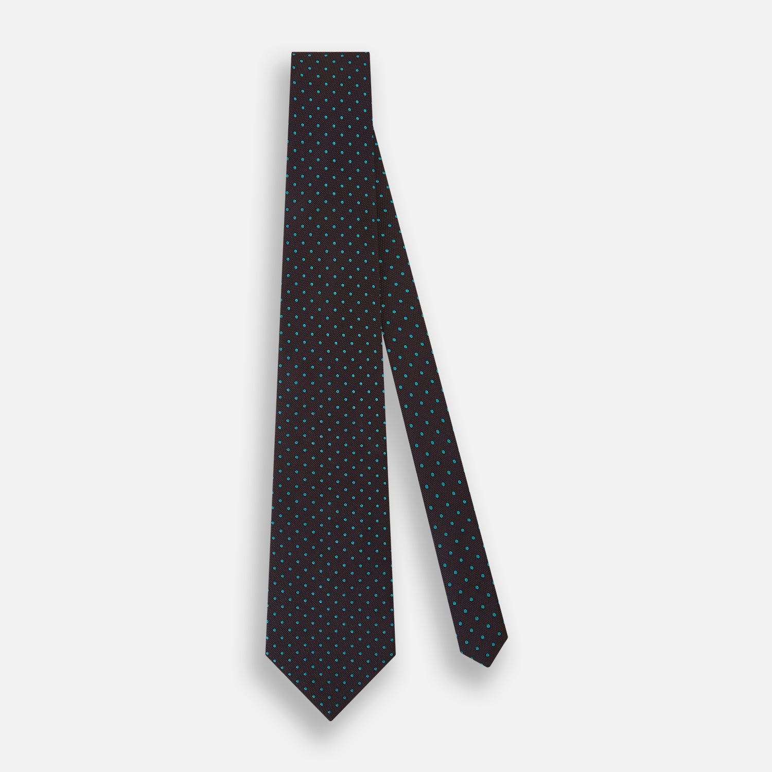 View 2 of product The Turnbull & Asser Turquoise and Forest Green Micro Dot Silk Tie is rolled up, showcasing evenly spaced micro dots on silk, displayed against a plain white background.