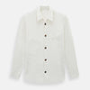 View 1 of product The Vanilla Linen Holland Shacket by Turnbull & Asser, a white Irish linen button-up with a collar, brown buttons, and four pockets, is laid flat on a white background—perfect as lightweight outerwear.