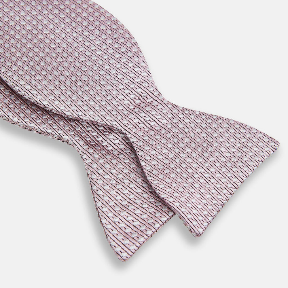 The Turnbull & Asser Pale Pink and White Square Silk Bow Tie features white stripes and subtle square patterns, ideal for formalwear. Shown on a white background.