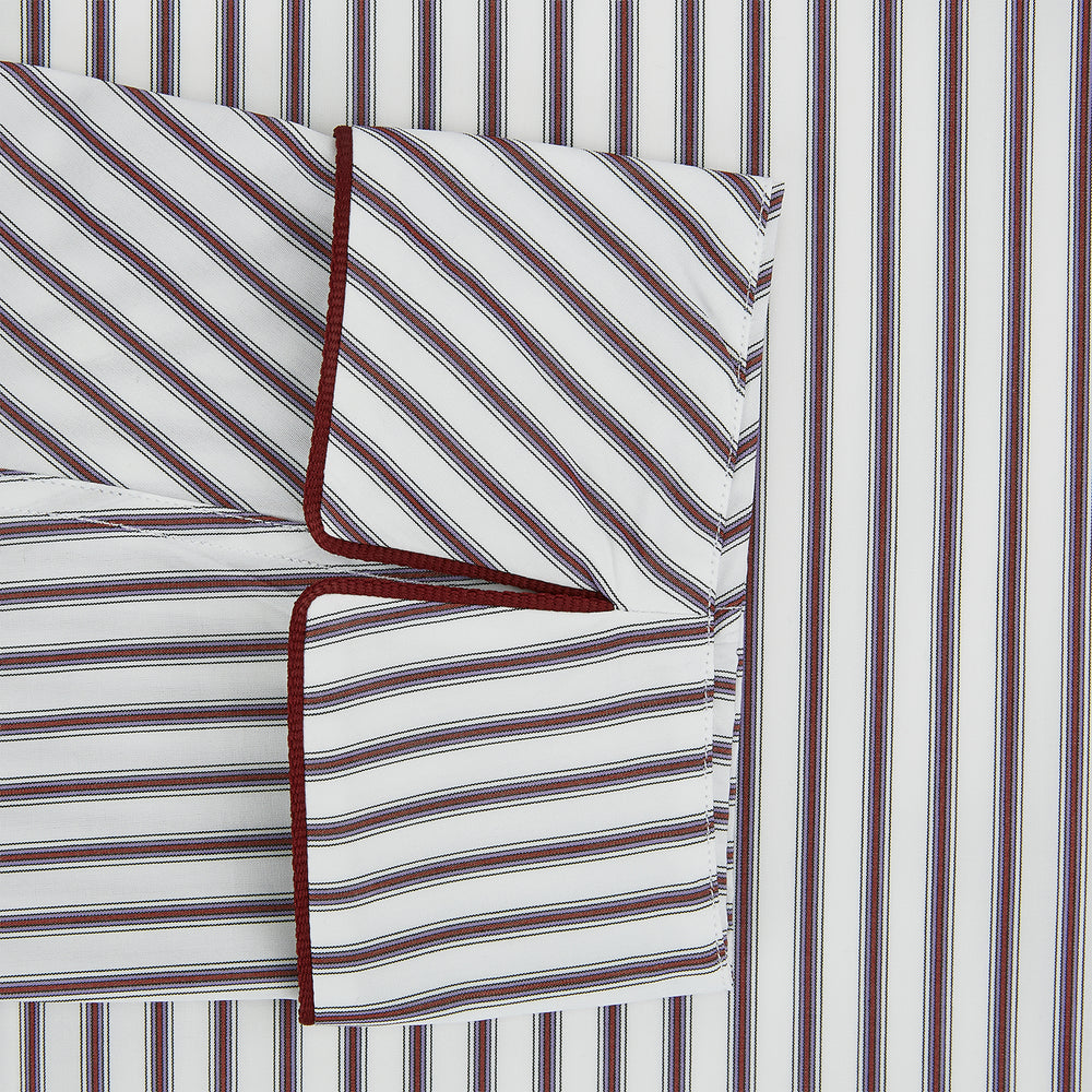 The Burgundy Multi Stripe Winston Gown by Turnbull & Asser features long sleeves, a shawl collar, waist belt, three pockets, and red piping accents for a classic Churchill-inspired touch.