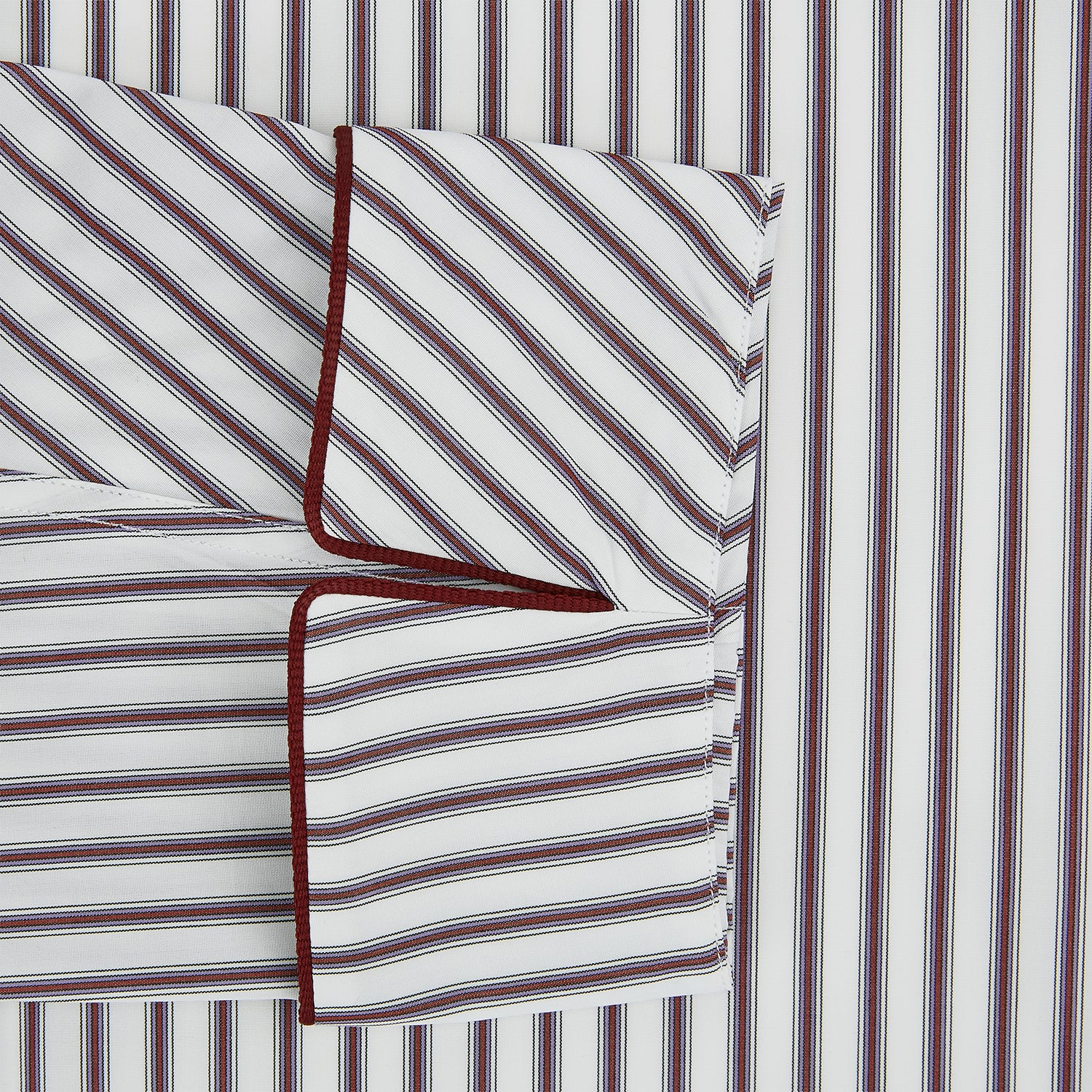 View 4 of product The Burgundy Multi Stripe Winston Gown by Turnbull & Asser features long sleeves, a shawl collar, waist belt, three pockets, and red piping accents for a classic Churchill-inspired touch.