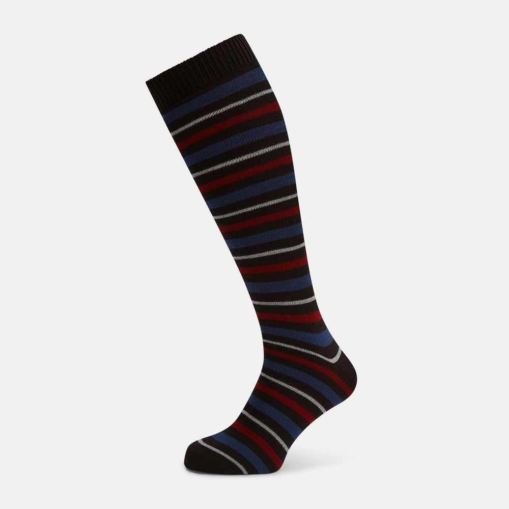 The Turnbull & Asser Dark Chocolate Striped Merino Wool Long Socks are knee-high, featuring horizontal black, red, blue, and gray stripes on a white background.