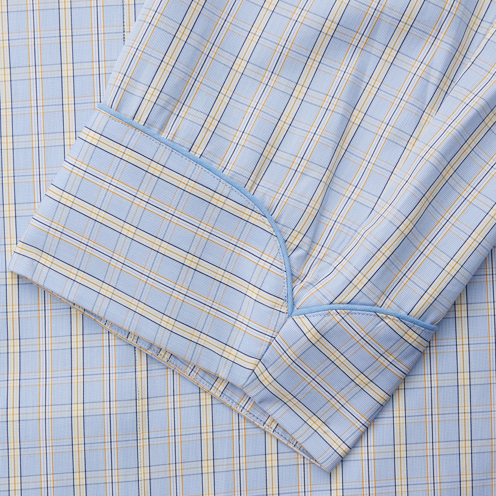 The Turnbull & Asser Blue and Yellow Check Poplin Cotton Dressing Gown features long sleeves, a shawl collar, front pockets, and a matching belt at the waist, shown on a plain white background.