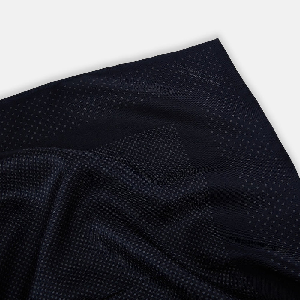 The Turnbull & Asser Navy and Charcoal Dot Silk Pocket Square features a subtle dotted pattern and a folded corner, shown on a white background.