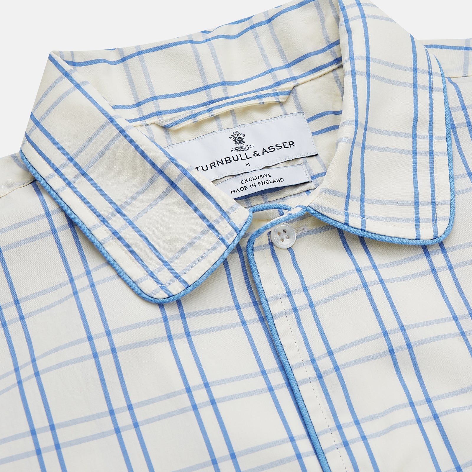 View 2 of product The Turnbull & Asser Cream Multi Cotton Sussex Nightshirt is a knee-length, long-sleeve shirt dress with a blue and beige plaid pattern, collar, front button placket, chest pocket, and rounded hem with side slits.