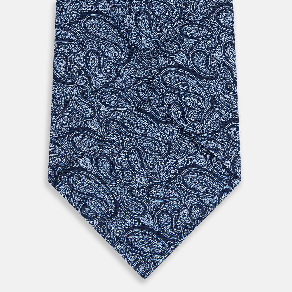 A rolled-up Turnbull & Asser Dark Navy Paisley Printed Silk Tie is shown on a plain light background.