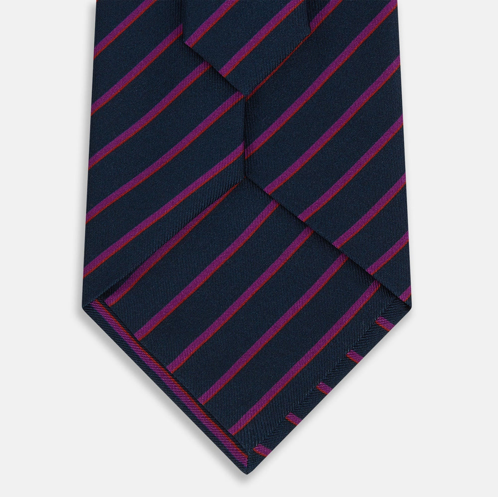 The Turnbull & Asser Navy and Purple Striped Blazer Silk Tie features British craftsmanship with diagonal magenta and purple stripes, displayed neatly rolled on a white background.