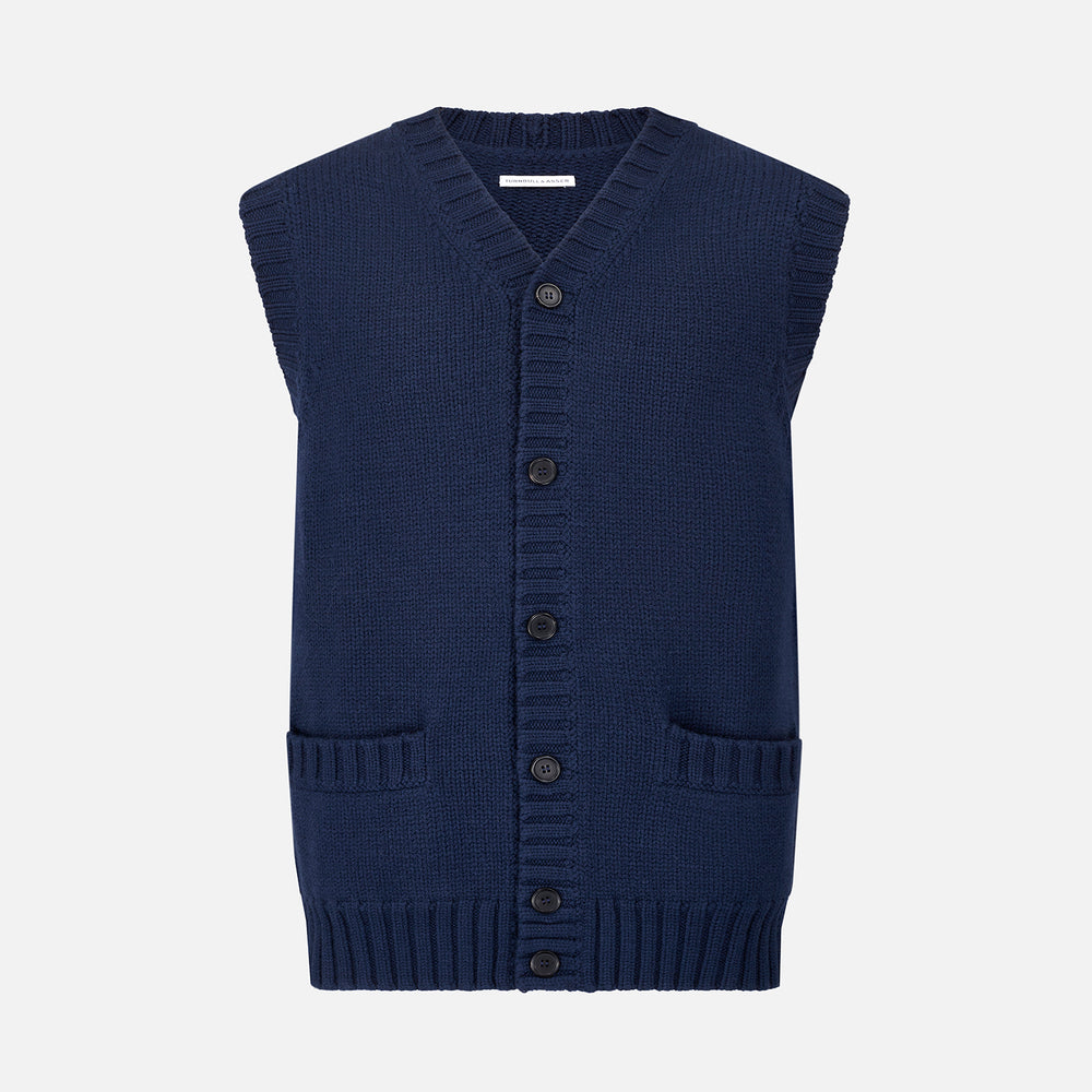 The NAVY MERINO V-NECK SLEEVELESS CARDIGAN by Turnbull & Asser features a button-down front, ribbed edges, and two front pockets—an elegant layering piece for stylish menswear.