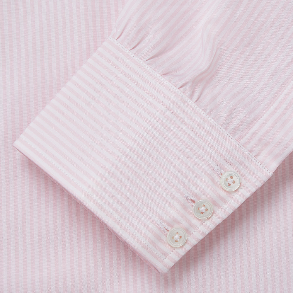 The Turnbull & Asser White and Pink Wide Stripe Mayfair Shirt features long sleeves, a collar, and bold vertical stripes, shown laid flat on a white background.