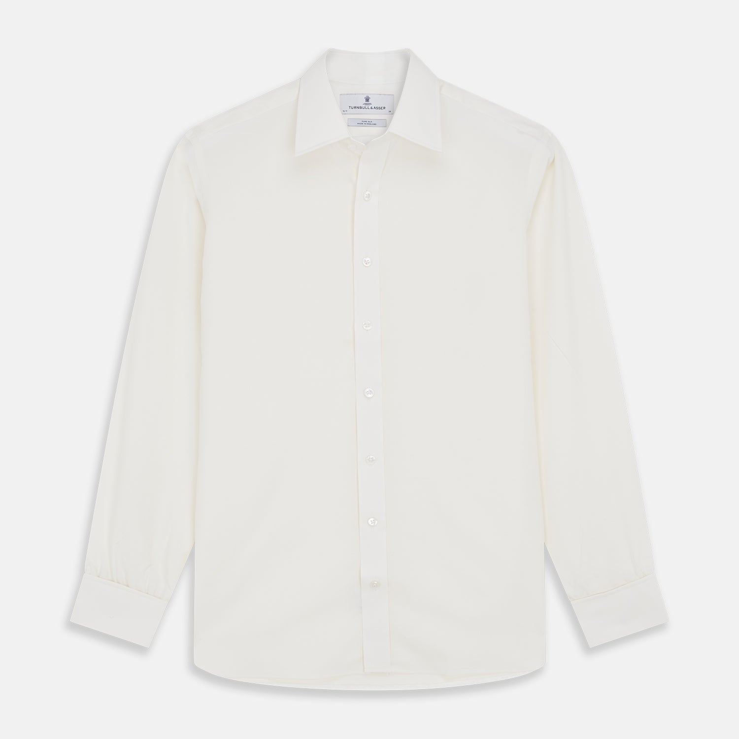 View 1 of product The Turnbull & Asser Cream Silk Tailored Fit Shirt is a long-sleeve button-up with a pointed collar and buttoned cuffs, displayed laid flat against a plain white background.