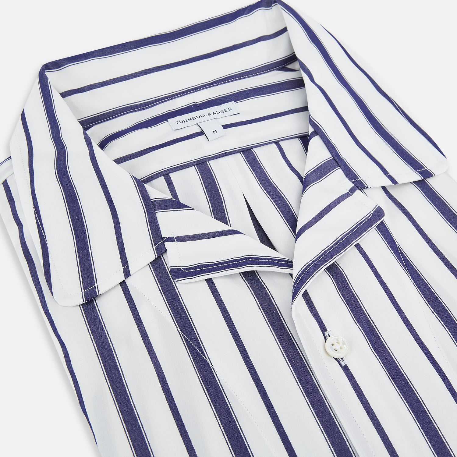 View 2 of product The Turnbull & Asser Navy Double Stripe Quarzo Nightshirt, a knee-length Italian cotton nightshirt with navy and white vertical stripes, collar, chest pocket, and button-down front, is displayed flat on a white background.