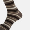 View 4 of product The Coffee Striped Merino Wool Long Socks by Turnbull & Asser feature knee-high length with horizontal brown, beige, and cream stripes, shown against a plain white background.
