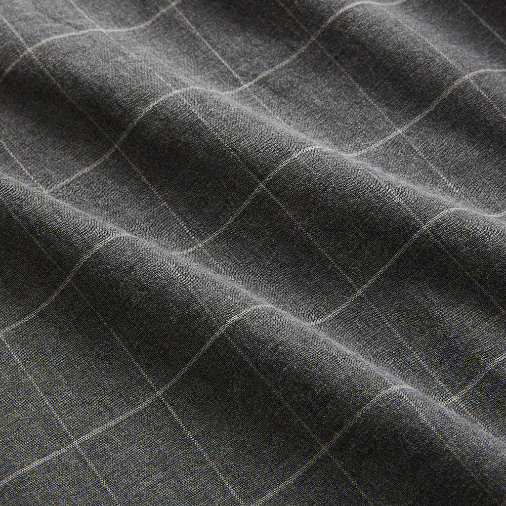 The Turnbull & Asser Charcoal Melange Check Hampstead overshirt, a long-sleeve button-up with a collar and two zippered side pockets, is laid flat on a light gray background.