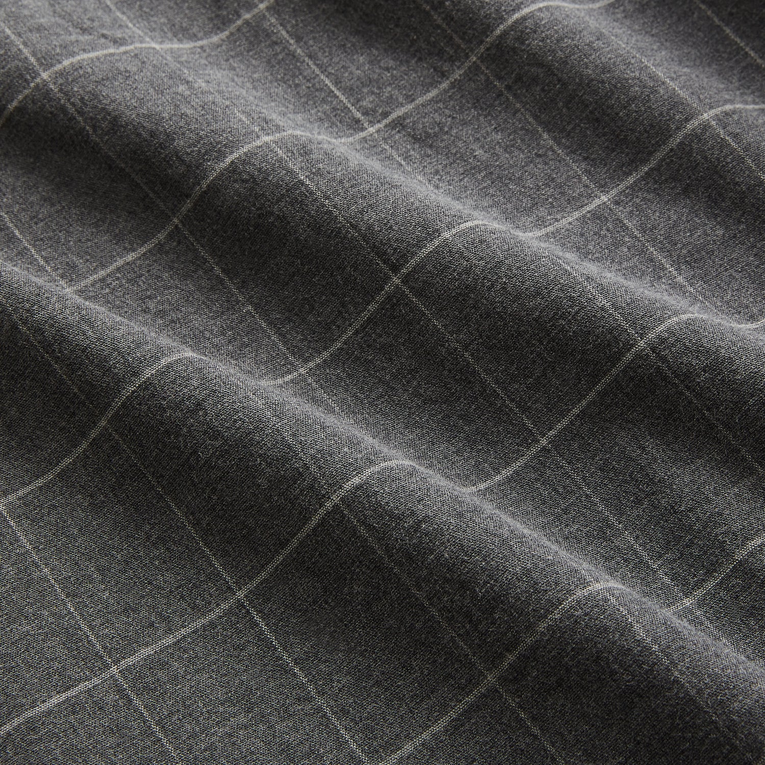 View 6 of product The Turnbull & Asser Charcoal Melange Check Hampstead overshirt, a long-sleeve button-up with a collar and two zippered side pockets, is laid flat on a light gray background.