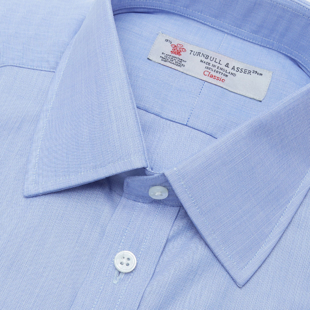 The Turnbull & Asser Blue End-on-End Cotton Shirt features a T&A collar, double cuffs, and white buttons—ideal for smart looks or pairing with a navy suit. Displayed against a plain white background.