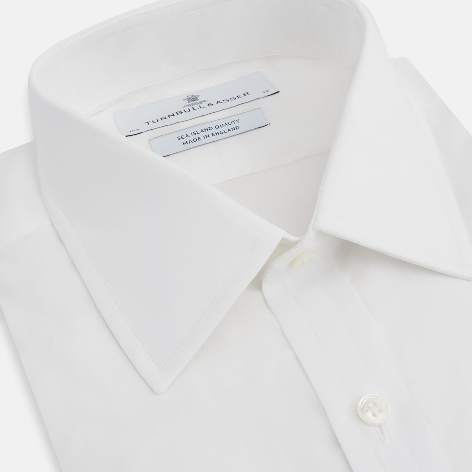 View 2 of product The Turnbull & Asser White Sea Island Quality Cotton Shirt features a T&A collar, double cuffs, and long sleeves, displayed against a white background.