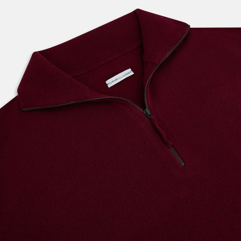 The Turnbull & Asser Ruby Red Half-Zip Cashmere Jumper, with a stand-up collar and elegant design, is displayed against a plain white background.