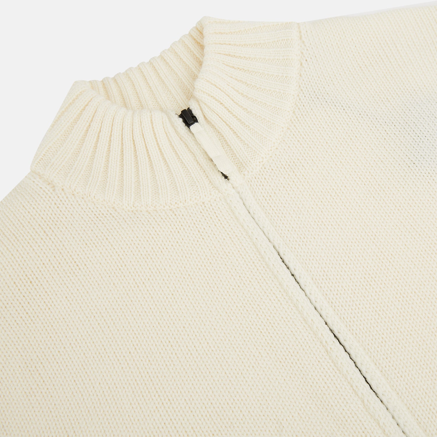 View 2 of product The White Merino High Neck Zipped Cardigan by Turnbull & Asser features a ribbed stand collar, cuffs, and hem. This elegant long-sleeve knitwear piece is shown on a plain white background.
