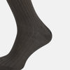 View 4 of product A single Concrete Grey Long Sock by Turnbull & Asser, featuring an over the calf fit and ribbed texture, is displayed on a plain white background.