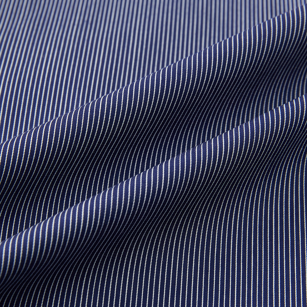 Turnbull & Asser’s Navy Stripe Highbury Overshirt with long sleeves, button-up front, black buttons, collar, and a left chest pocket is shown laid flat on a white background.