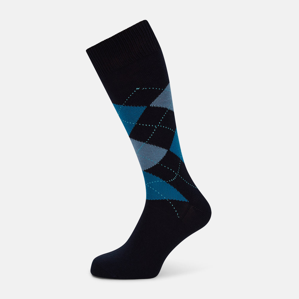 The Turnbull & Asser Navy Check Mid-Length Sock, crafted from ultra-soft cotton, features a blue and light blue argyle pattern with diamond shapes and dotted lines, and is showcased against a plain white background.