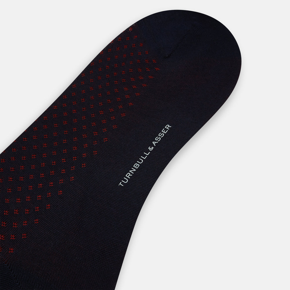 A single Navy/Red Motif Mid-Length Sock by Turnbull & Asser, displayed upright on a white background. The sock features a calf-length style, ribbed cuff, hand-linked toe for comfort, and a subtle red pattern.
