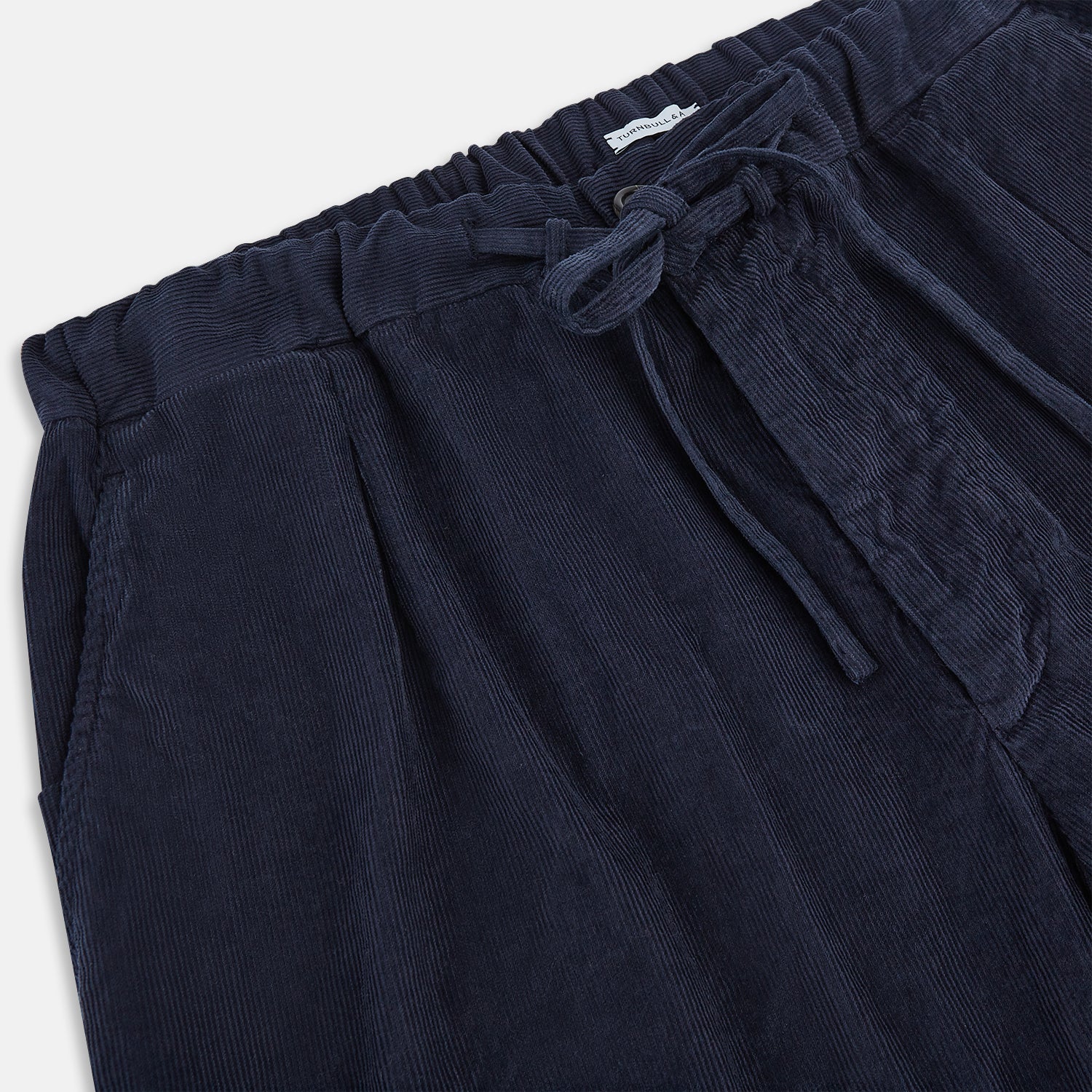 Image 2 of product Turnbull & Asser's Light Navy Corduroy Miles Trousers feature a straight-leg stretch fit, elasticated waist, and matching fabric drawstring, shown on a plain white background.