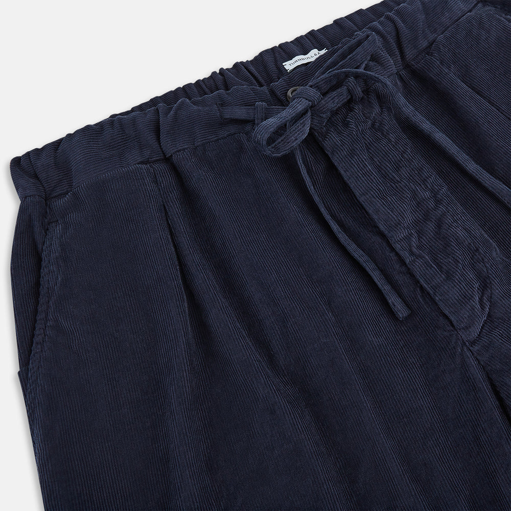 Turnbull & Asser's Light Navy Corduroy Miles Trousers feature a straight-leg stretch fit, elasticated waist, and matching fabric drawstring, shown on a plain white background.