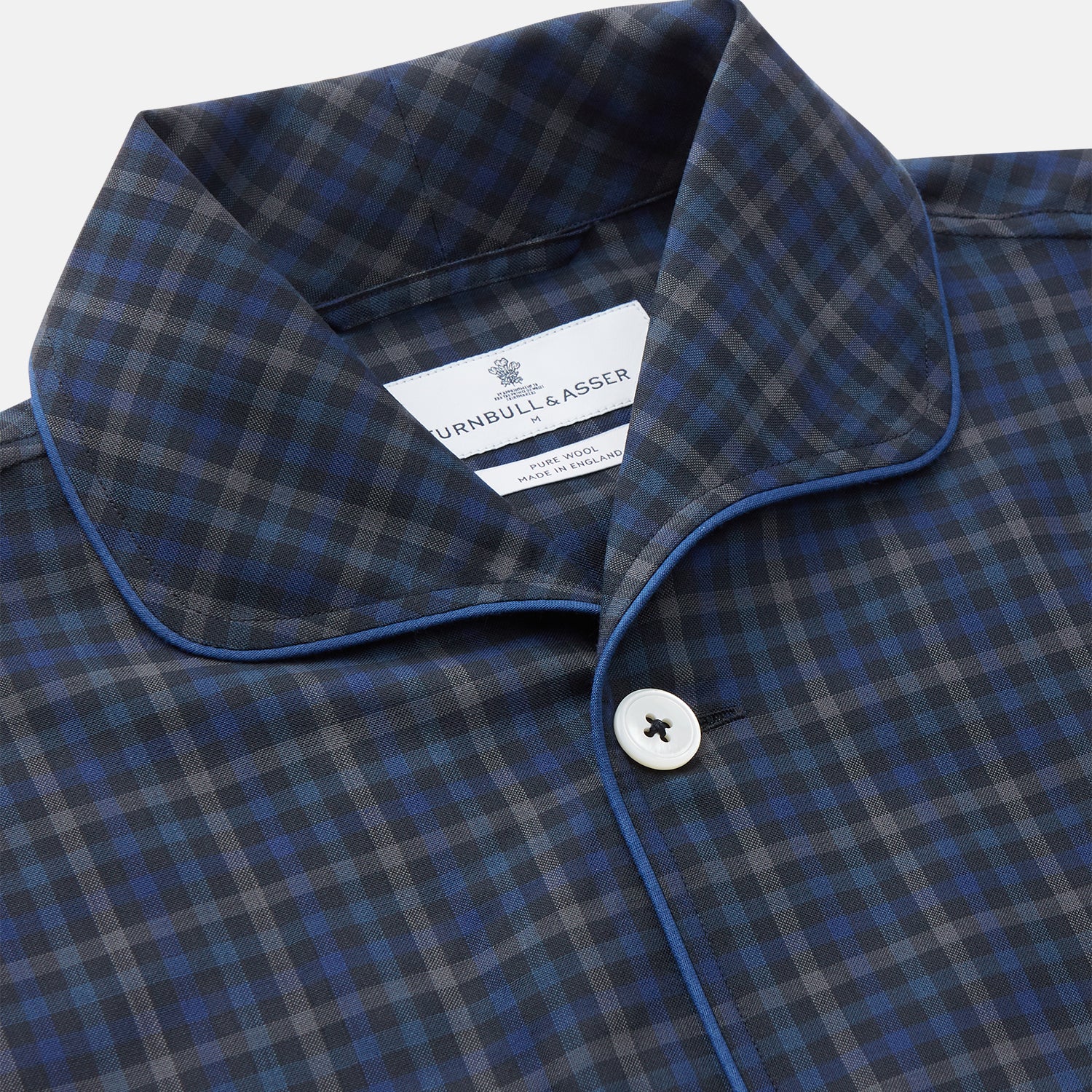 View 2 of product The Turnbull & Asser Blue Multi Check Wool Quin Pyjama Set features a long-sleeve button-up top with chest pocket and drawstring pants, both displayed flat on white—a luxurious choice for refined sleepwear.