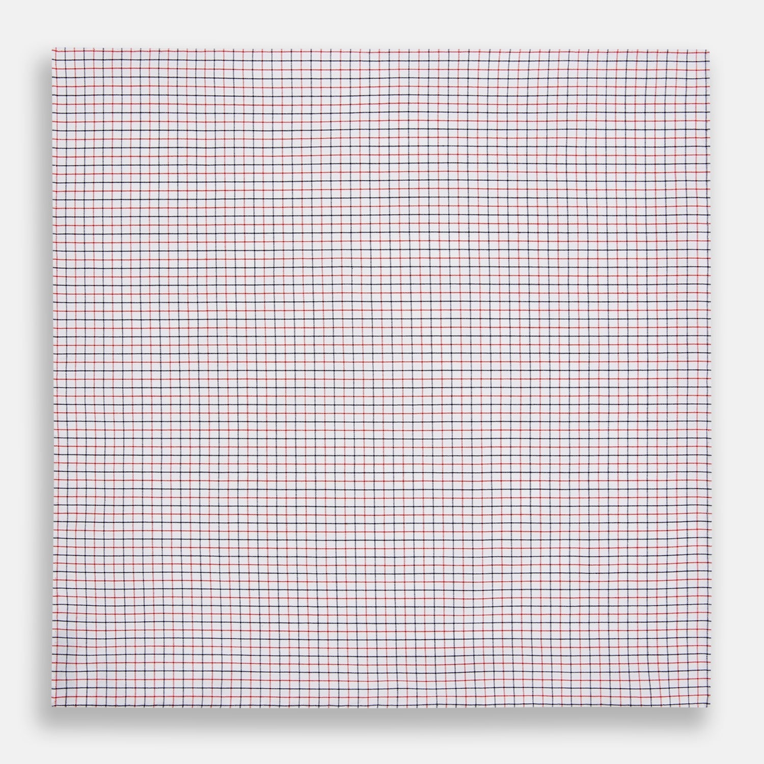 View 3 of product Turnbull & Asser’s Hand Rolled Red and Navy Graph Check Handkerchief—a white cotton accessory with red and navy grid lines, neatly folded for a touch of refined elegance.