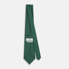 View 4 of product The Forest Green Geometric Floral Printed Silk Tie by Turnbull & Asser is shown rolled up on a white background, its English silk material featuring an elegant green and turquoise pattern.
