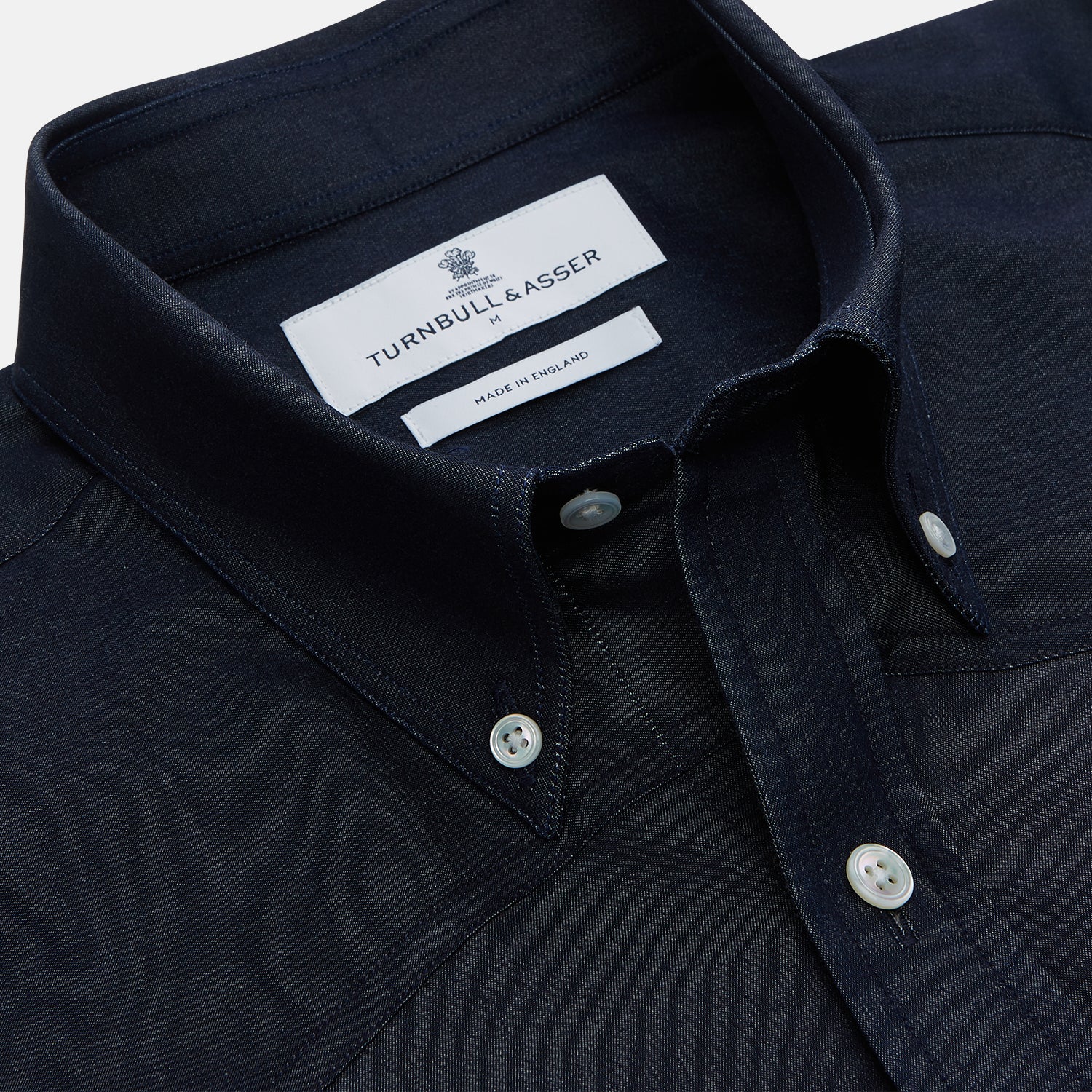 View 2 of product The Turnbull & Asser Navy Weekend Fit Larkin Shirt features a Dorset collar, long sleeves with 3-button cuffs, two chest pockets, and white snaps, shown laid flat against a white background.