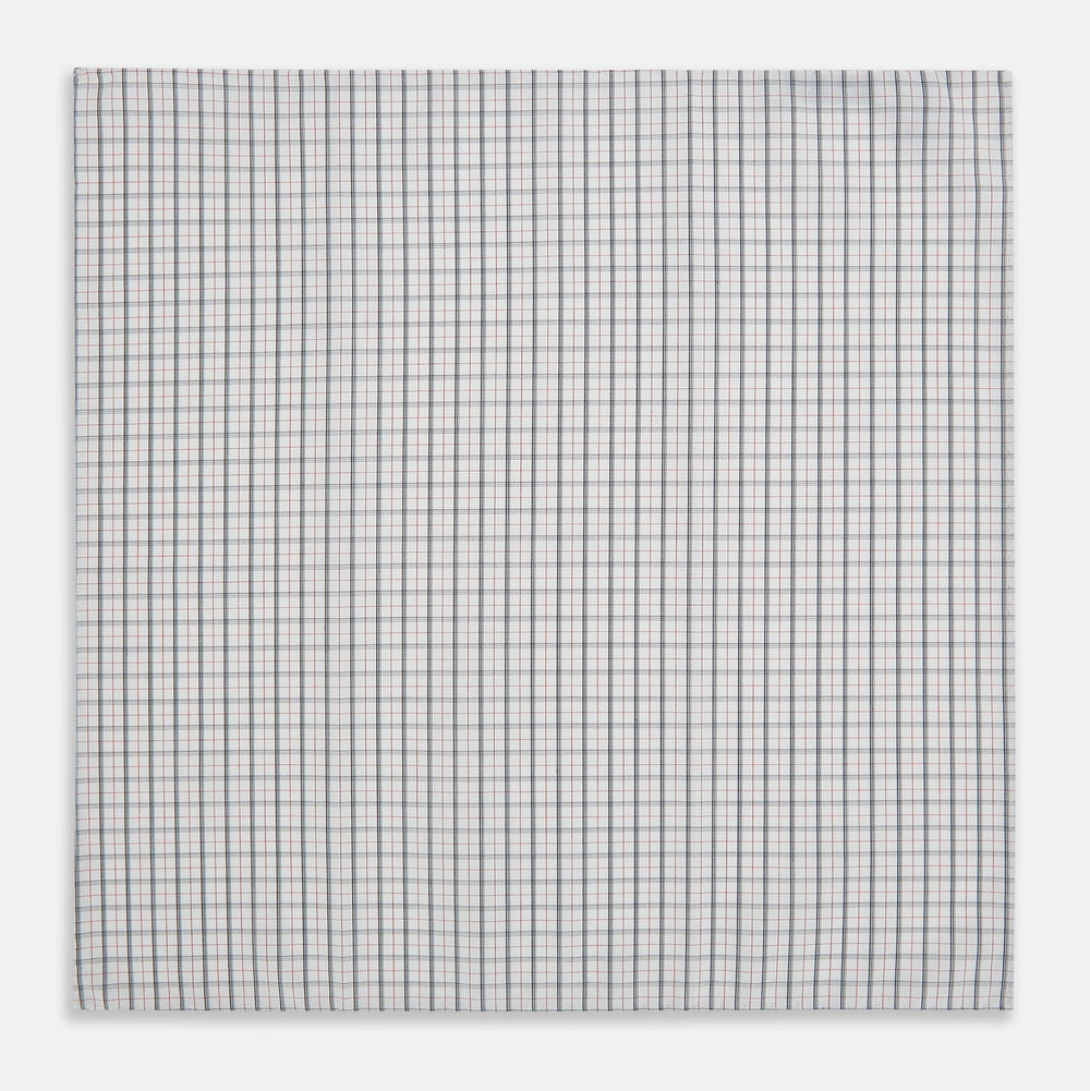 The Red Multi Graph Check Hand-Rolled Handkerchief by Turnbull & Asser features thin black, red, and blue lines forming small squares on white fabric, finished with delicate hand-rolled edges.