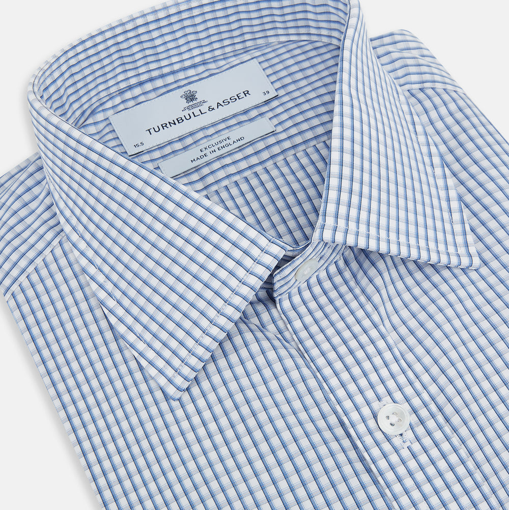 The Sky Blue Micro Shadow Check Mayfair Shirt by Turnbull & Asser features long sleeves, a classic collar, buttoned cuffs, and a light blue and white micro check pattern—showcasing refined British craftsmanship.