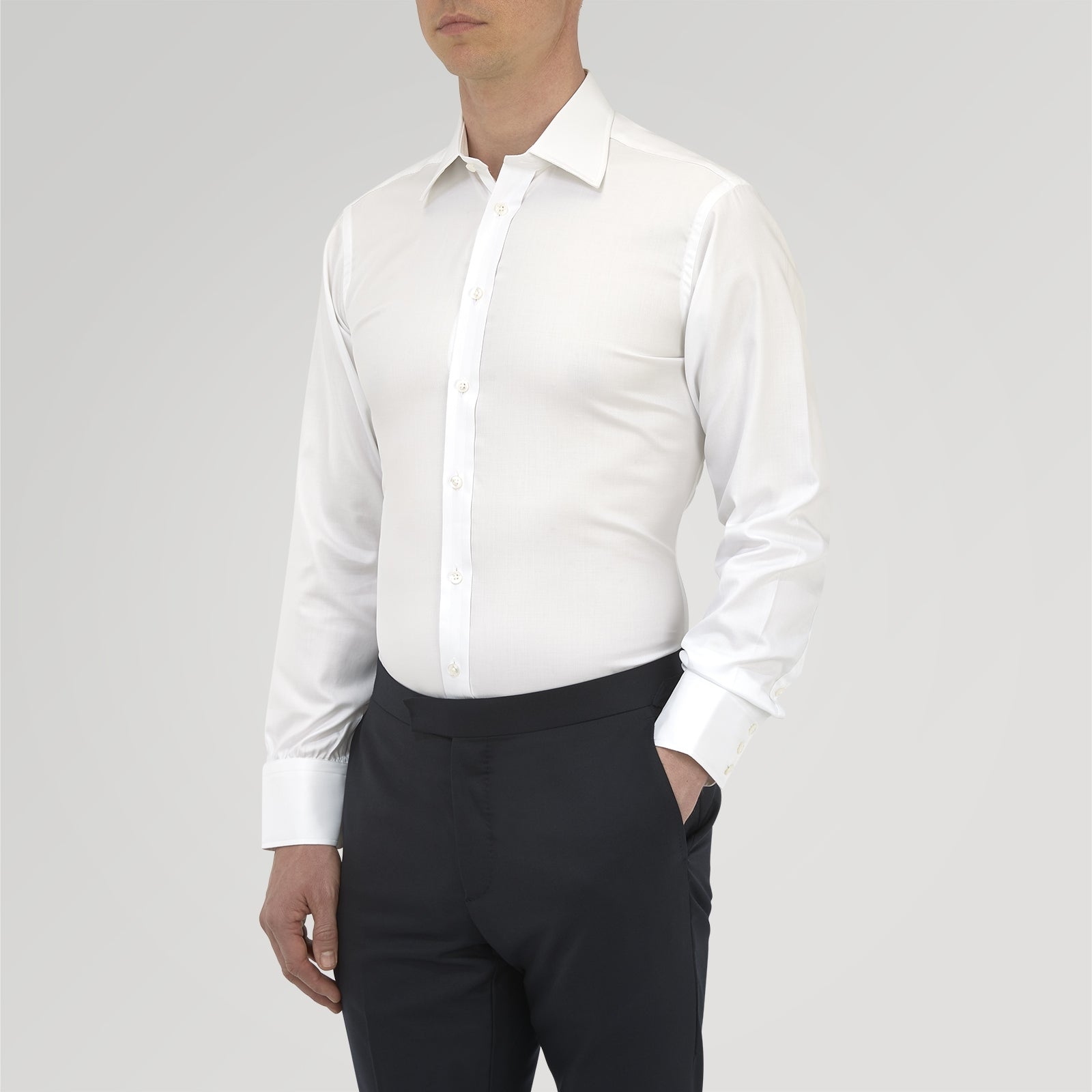 View 2 of product A neatly folded White Sea Island Quality Cotton Twill Shirt by Turnbull & Asser, featuring a T&A collar and 3-button cuffs, is displayed on a light grey background with a label visible inside the collar.