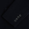 View 4 of product The Turnbull & Asser Navy Knitted Cambridge Blazer features a single-breasted design with three front patch pockets and two buttons, shown against a plain white background.