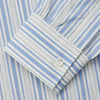 View 4 of product The Turnbull & Asser Blue Multi Stripe Wool Blend Weekend Fit Hayne Shirt features vertical blue, yellow, and white stripes, a button-down collar, and buttoned cuffs. Laid flat on a white background.