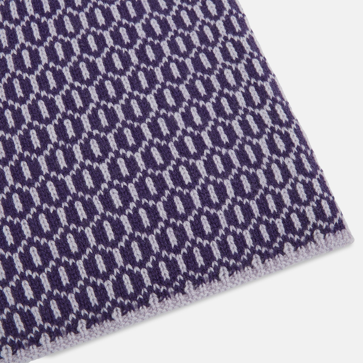 Image 2 of product The Turnbull & Asser Purple and Lilac Hexagon Cashmere Knitted Scarf, featuring a white hexagon pattern, is neatly knotted and displayed on a plain background—a stylish accessory to elevate any outfit.