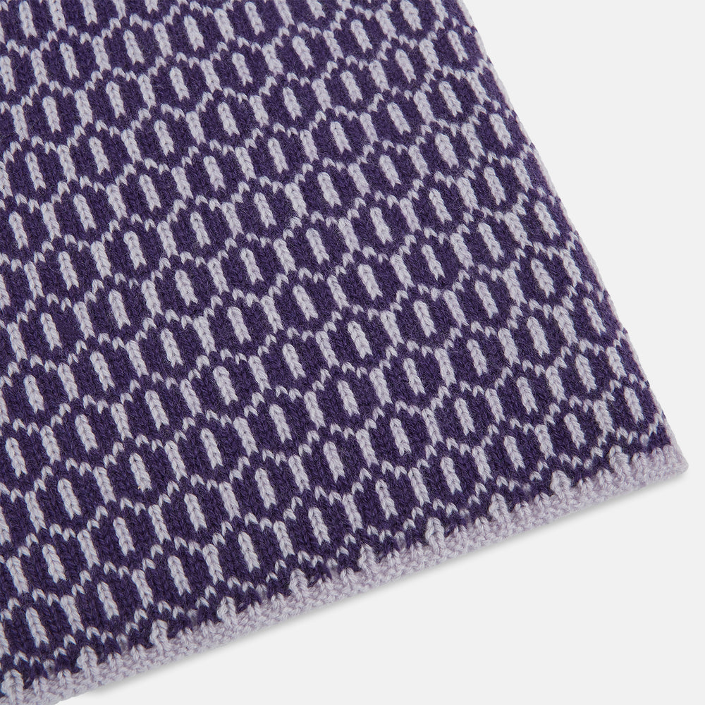 The Turnbull & Asser Purple and Lilac Hexagon Cashmere Knitted Scarf, featuring a white hexagon pattern, is neatly knotted and displayed on a plain background—a stylish accessory to elevate any outfit.