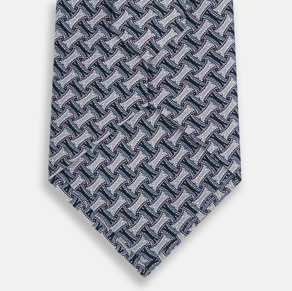 The Turnbull & Asser Navy and Pink Weave-Patterned Printed Silk Tie is shown rolled up on a white background, featuring a stylish geometric design.