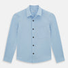 View 1 of product The Blue Hyde Overshirt by Turnbull & Asser features a light blue hue, long sleeves, a button-up front, and a single chest pocket. Crafted from sanforised cotton and shown laid flat on a white background.