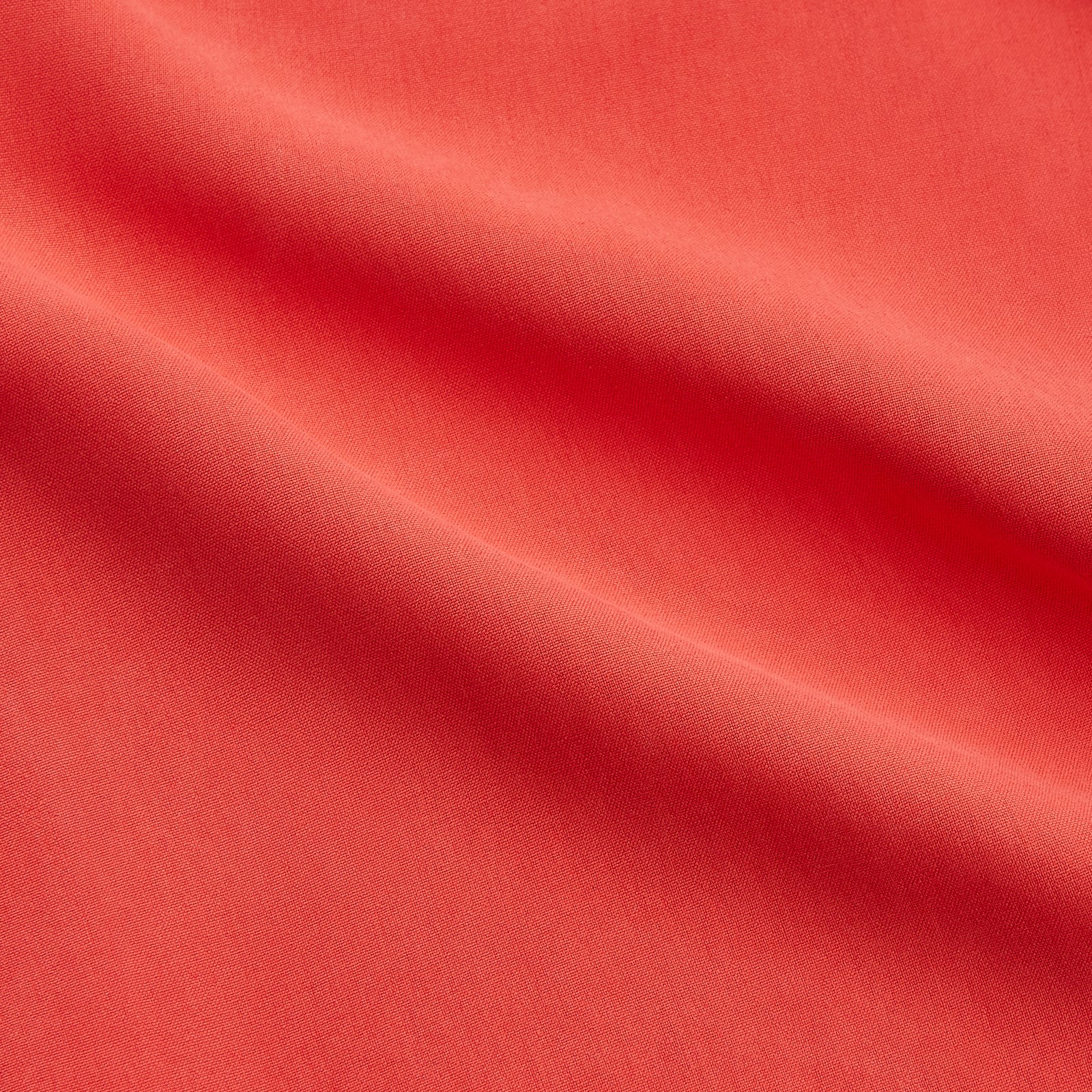 View 2 of product The Turnbull & Asser Women's Coral Pink Silk Thelma Pyjama Set features a long-sleeve button-up top with two front pockets and matching drawstring pants, shown on a white background.