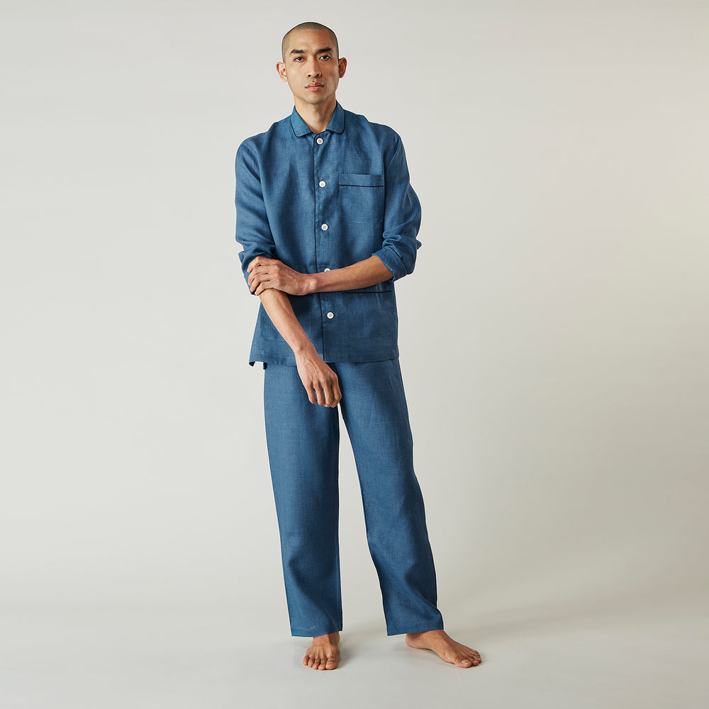 A person stands barefoot against a plain background, wearing the Teal Linen Modern Pyjama Set from Turnbull & Asser.